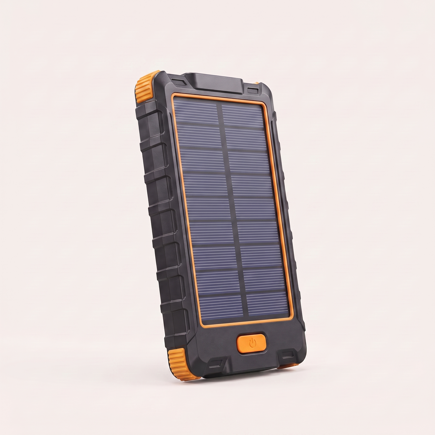 Rugged solar power bank standing upright on a plain light grey background, matte black textured body with bright orange ribbed corner bumpers, a solar panel across the front and a small orange power button below it.